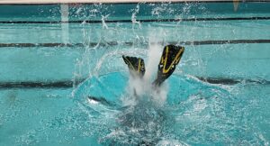 A snorkellers splashes as they enter the pool